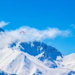 Parapentiste arpentant les montagnes enneigées