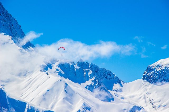 Parapentiste arpentant les montagnes enneigées